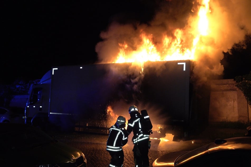 Kameraden der Feuerwehr löschen einen brennenden Lkw in Leipzig-Nord.