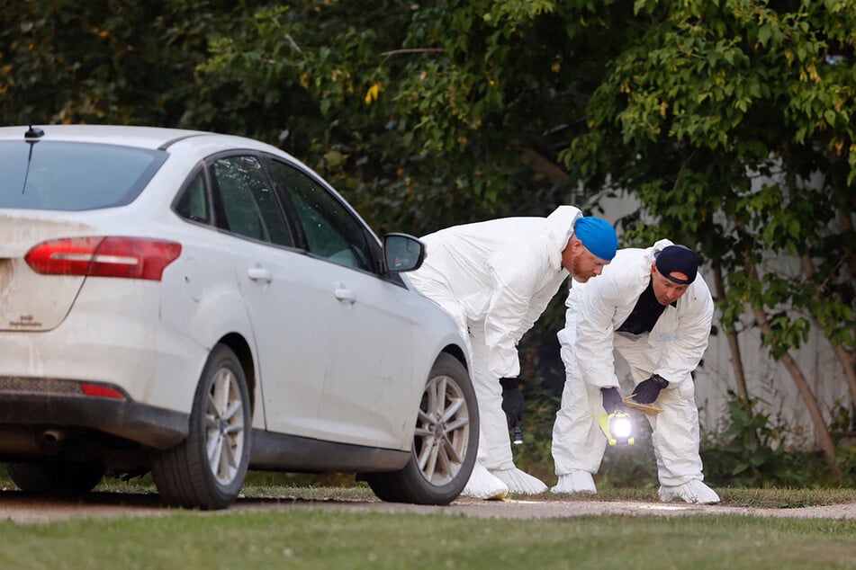 Forensic investigators at the scene in the village of Weldon, Saskatchewan.