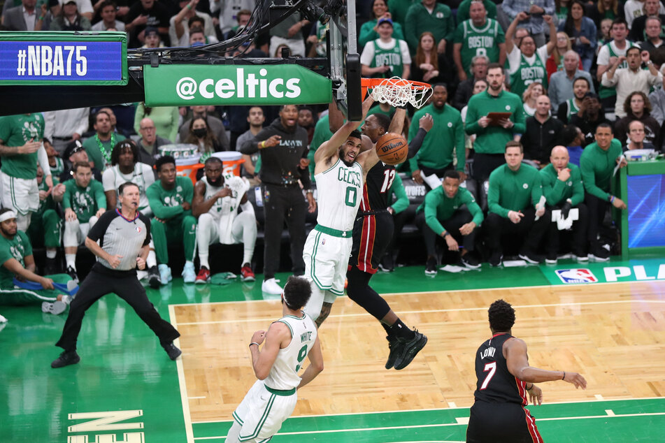 Tatum hangs from the hoop dunking on the Heat.