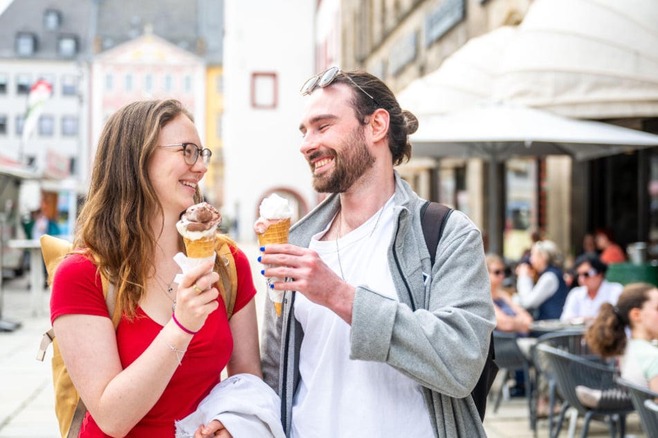 Studentin Anny Schmidt (22) und ihr Freund Marvin Müller (26) essen Eis vorm Rathaus.