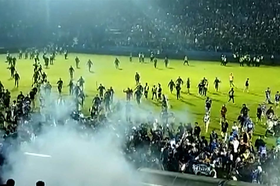 Videos from Saturday night's game showed tear gas in the crowd as people ran on the pitch after a match between Arema FC and Persebaya Surabaya at Kanjuruhan stadium in Malang, East Java. At least 125 people died when fans invaded the pitch and police responded with firing tear gas, officials said.