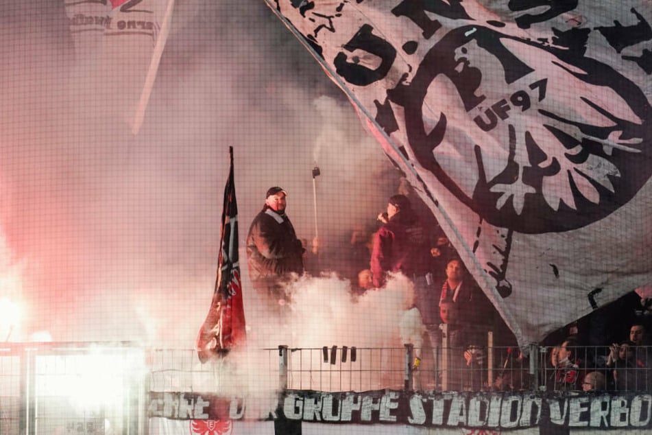 Für die Plakate werden die Vereine sicherlich nicht zur Kasse gebeten, wohl aber für das Abfackeln von Pyrotechnik. Die Eintracht-Fankurve lag vor dem Spiel in dichtem Rauch.
