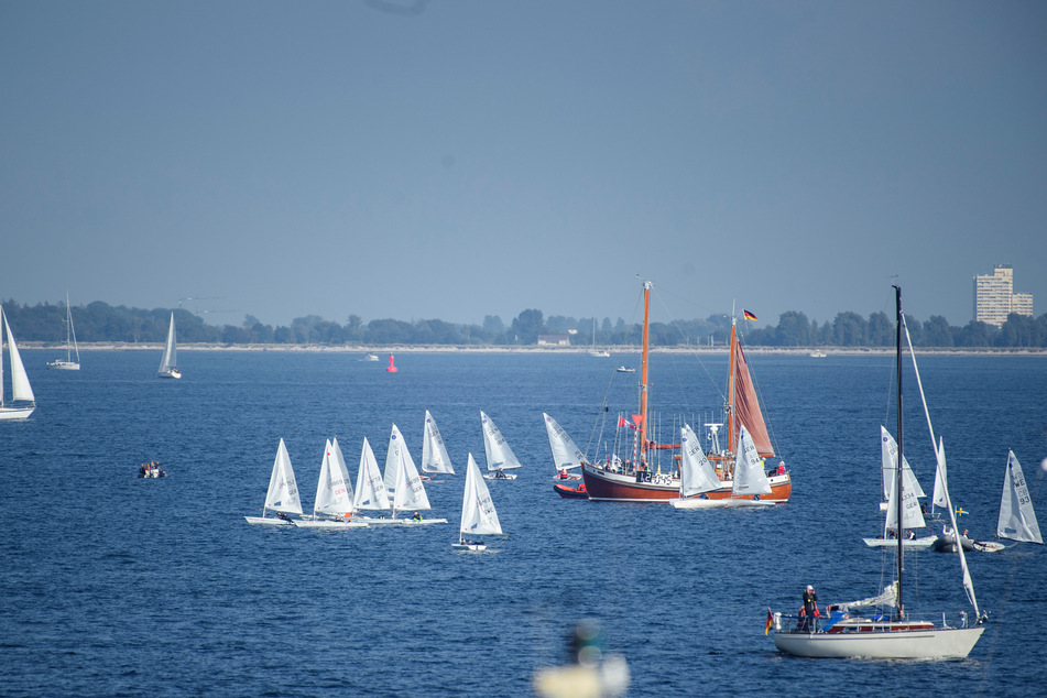Segelboote der Klasse ILCA 4 warten während der Eröffnung der Kieler Woche 2021 auf der Ostsee vor dem Olympiastützpunkt Schilksee.