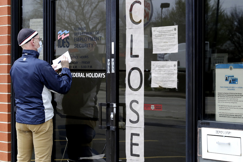 Chicago: Ein Mann schreibt vor dem Arbeitsministerium etwas auf einen Zettel. Während der Corona-Pandemie gab es bislang in den USA 12,9 Millionen Arbeitsplatzverluste und viele Geschäfte mussten geschlossen werden.