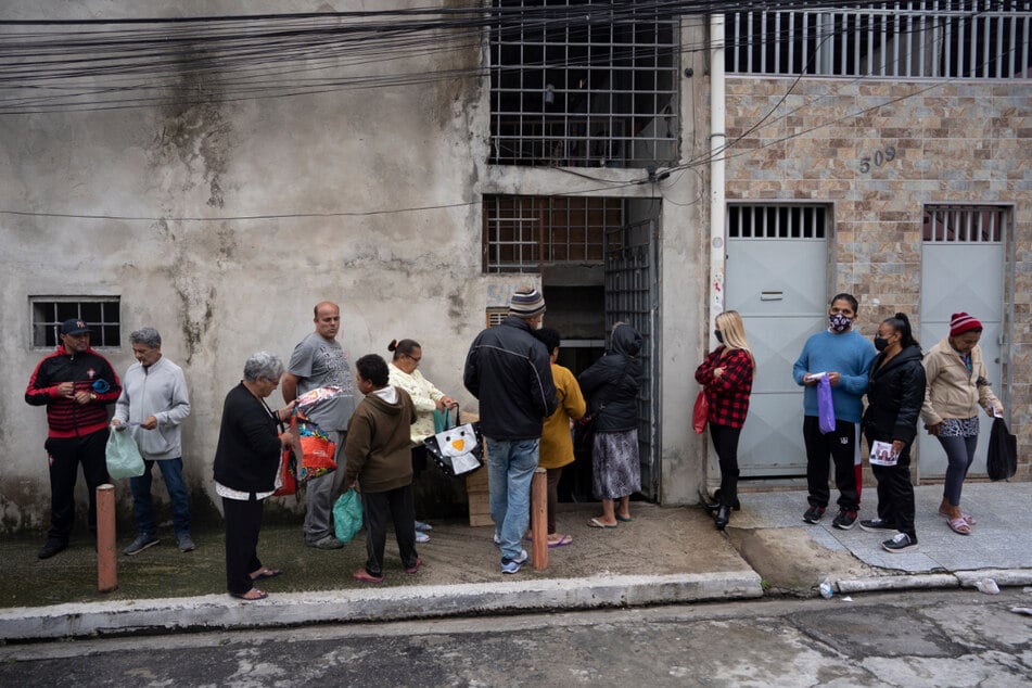 Menschen stehen vor einer Suppenküche in Sao Paulo an, um eine Mahlzeit zu erhalten.