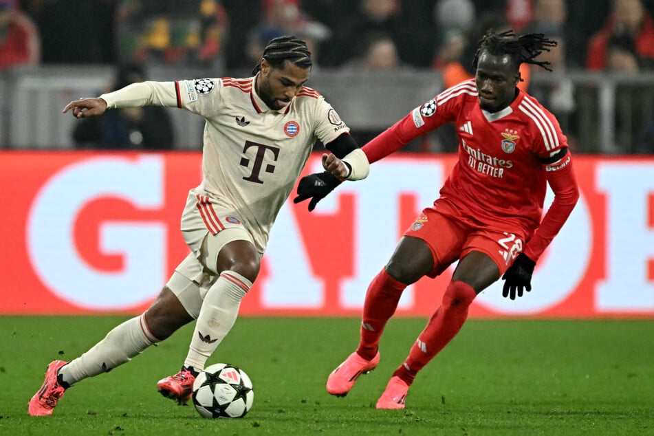 Bayern Münchens Serge Gnabry (l.) behauptet sich im Zweikampf um den Ball gegen Benficas Issa Kabore.