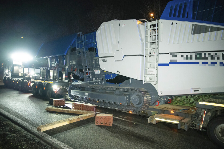 Der 76 Tonnen schwere Steinbrecher rutschte in einer Kurve von der Ladefläche des Schwertransports.