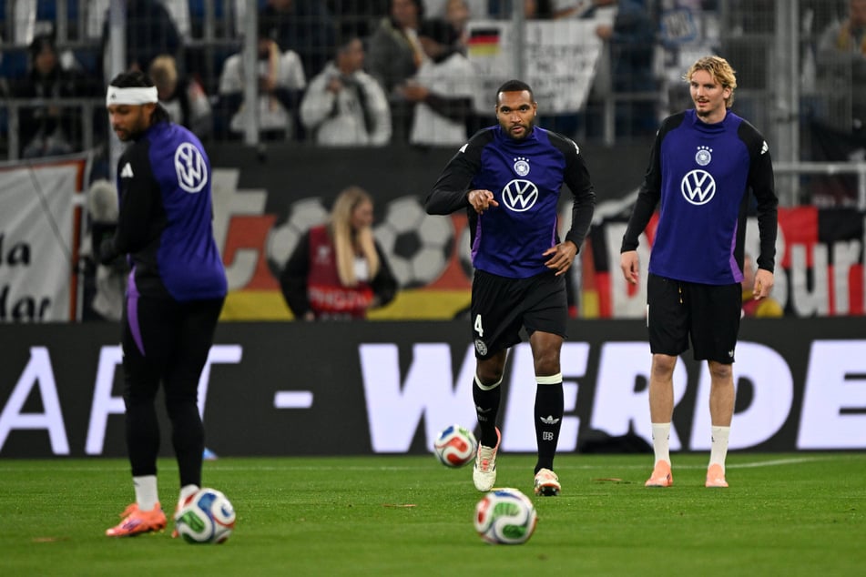 Die Teams machen sich auf dem Rasen warm.