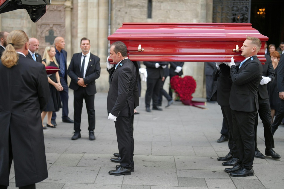 Der auffällig rote Sarg wurde nach der Zeremonie aus dem Stephansdom getragen.