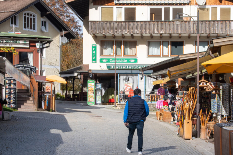 Ein Mann läuft die ansonsten leere Seestrasse in Berchtesgaden entlang, die zum Königssee führt.