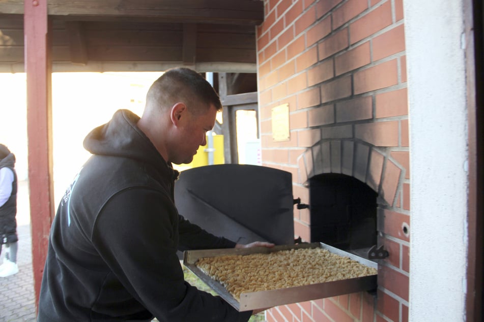 Tobias Höll, Leiter des Fördervereins "Erlebnisdorf Taura", backt Kuchen im Dorf-Backofen.