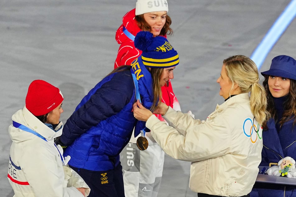 Ebba Andersson aus Schweden (Mitte) erhält die Goldmedaille, weil sie auf der 50-Kilometer-Distanz die Konkurrenz in die Schranken wies.