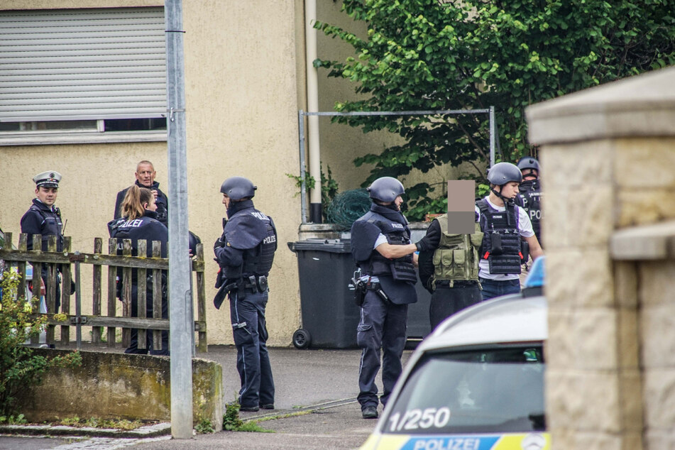 Einsatzkräfte führen einen Mann ab.