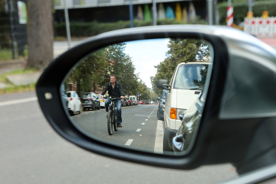 So ist es richtig: Radler fahren außerhalb der gestrichelten Linien, um nicht von einer aufgehenden Autotür erwischt zu werden.