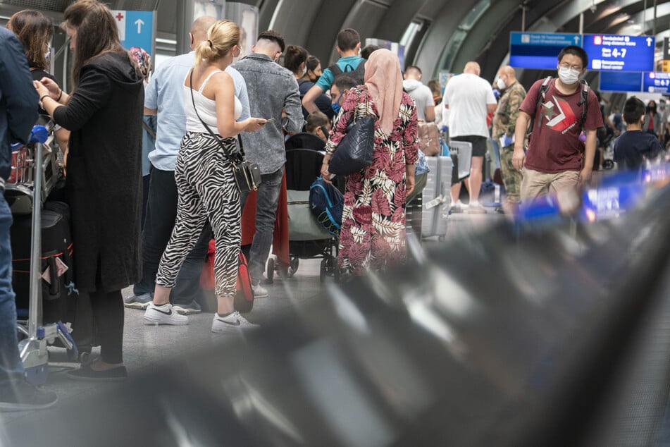 Passagiere warten in einer langen Schlange am Frankfurter Flughafen auf einen kostenlosen Corona-Test.