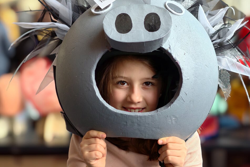 Auf der Suche nach einem Faschingskostüm setzt sich Lotte eine Maske auf.