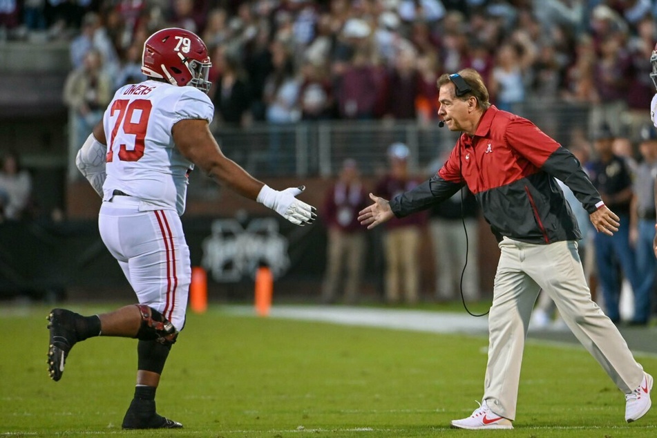 Crimson Tide head coach Nick Saban (r) gives a high-five to Alabama Crimson Tide offensive lineman Chris Owens (l).