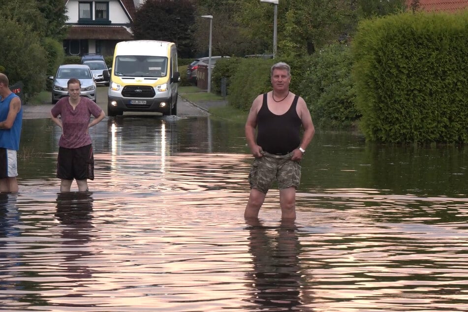 Anwohner des Landkreis Aurich (Niedersachsen) erfrischten sich offenbar in den vom Regen überfluteten Straßen.