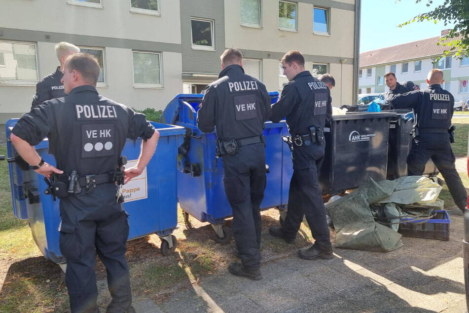 Polizisten suchen in der Umgebung des Tatortes in Bad Fallingbostel nach Beweismitteln.