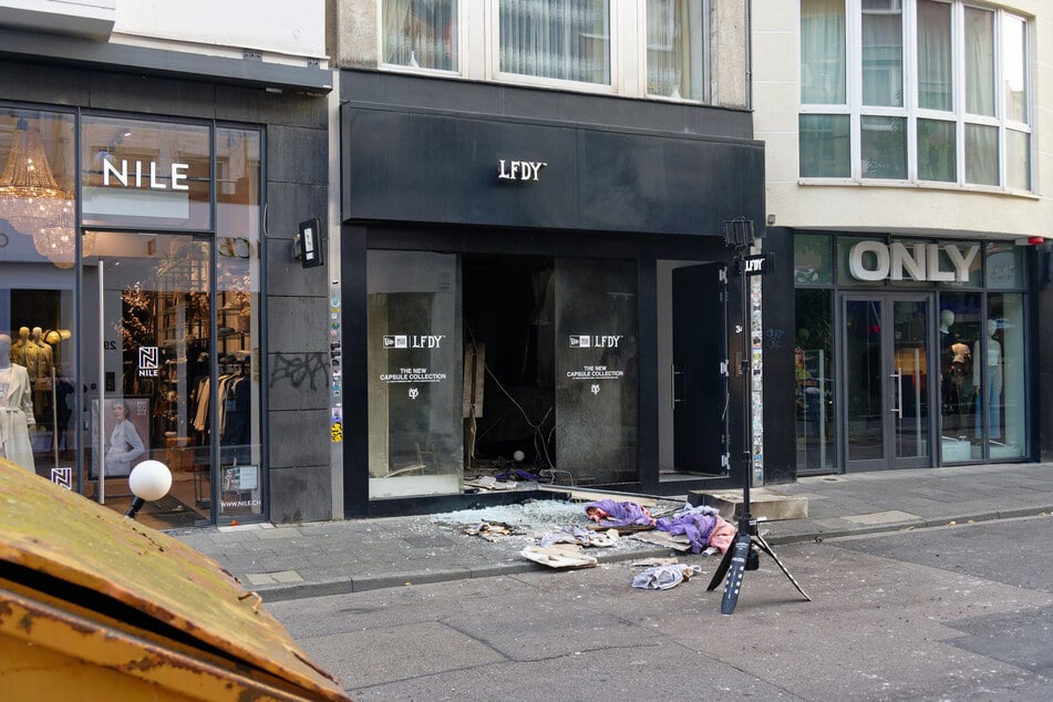 Scherben und Kleidungsstücke liegen vor einem Geschäft in der Ehrenstraße in Köln. Dort hatte es im September eine Explosion gegeben.