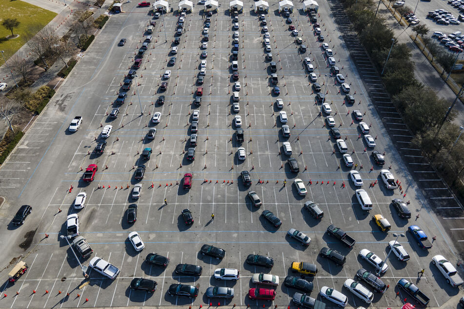 Autos stehen auf einem Parkplatz am NRG Park in Houston in einer Schlange, während die Fahrer darauf warten, gegen das Coronavirus geimpft zu werden. Die große Impf-Einrichtung in Harris County wird staatlich gefördert.
