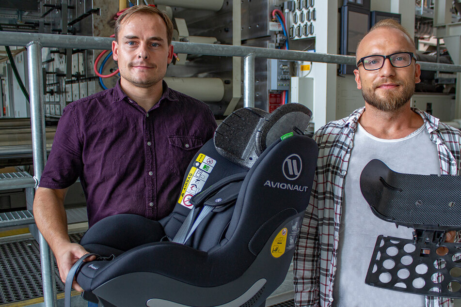Die TU-Forscher Norbert Schramm (36, l.) und Tomasz Osiecki (33) präsentieren den Kindersitz mit der neu entwickelten Kopfstütze.