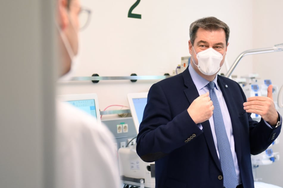 Markus Söder (CSU), bayerischer Ministerpräsident unterhält sich im Krankenhaus München Schwabing in einem Zimmer der Intensivstation mit Krankenhausmitarbeitern.