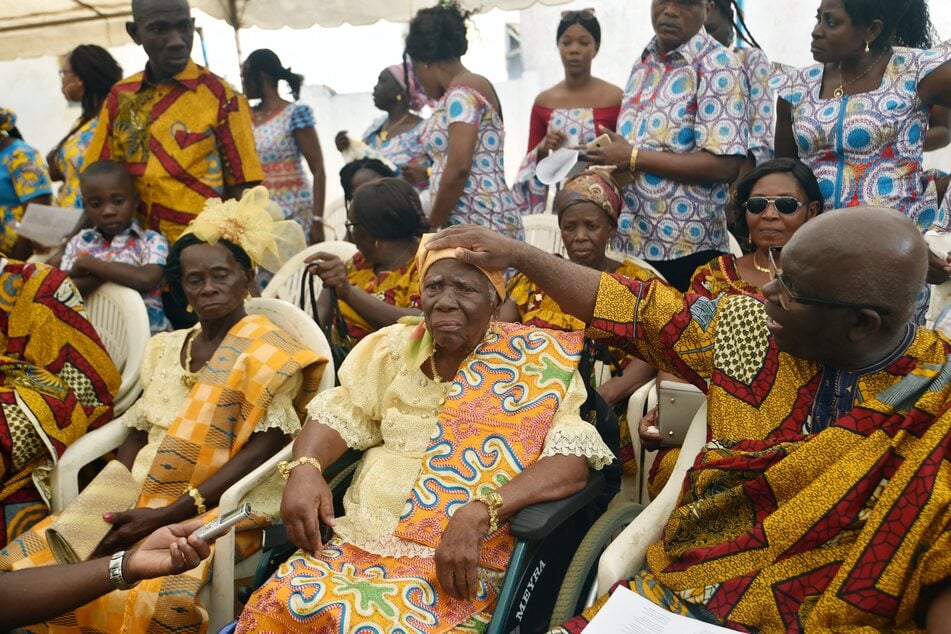 The almost century-old Jeanne Danho Yace (c.) who was born in 1923 according to her birth certificate, attends her birthday celebration with her relatives at the Catholic church of Grand-Jacques, sub-prefecture of Jacqueville on August 4, 2018. In a country where life expectancy is around 55 years old, elderly people are celebrated by songs and dances for their birthdays or their funerals.