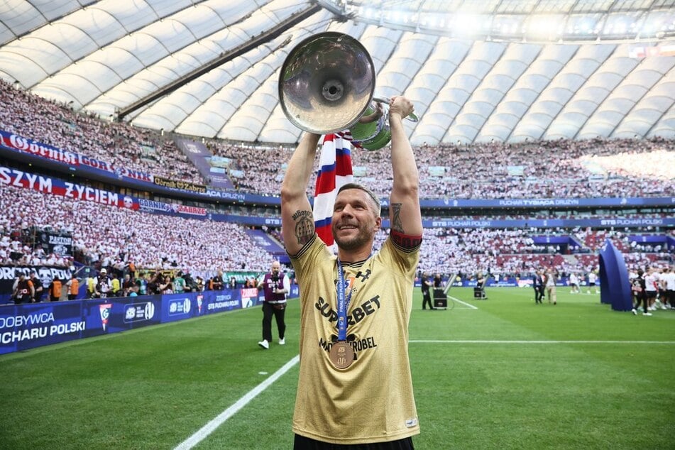 Lukas Podolski (40) von Gornik Zabrze jubelt mit der polnischen Pokal-Trophäe nach dem Sieg über Rakow Czestochowa.