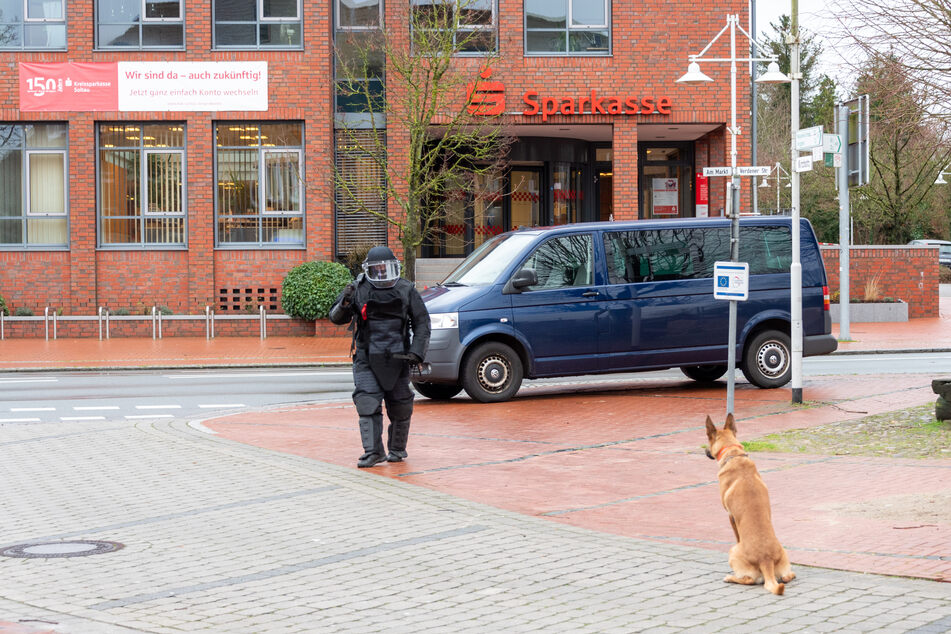 Ein Sprengstoffspürhund wartet auf das Signal die Geschäftsstelle der Sparkasse Soltau zu durchsuchen.