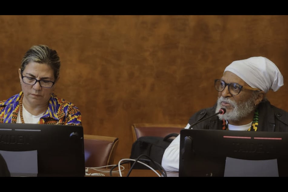 Dr. Kwame-Osagyefo Kalimara (r.) speaks as Dr. Kenia Serrano Puig listens during a side event on Cuba's revolutionary legacy at the United Nations in Geneva, Switzerland, on April 17, 2026.