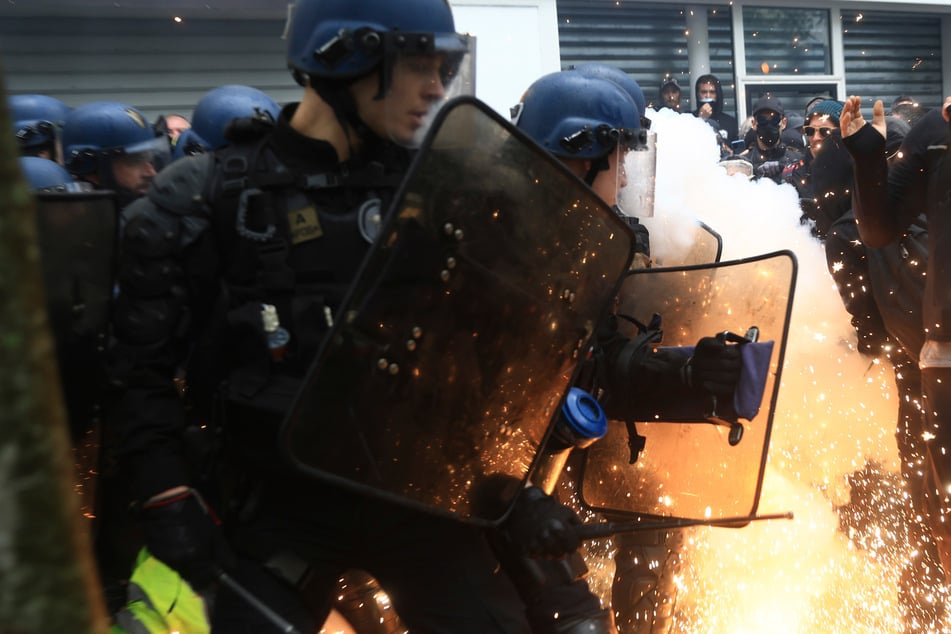 Pariser Polizisten wehrten zum Tag der Arbeit die Pyrotechnik einiger Demonstranten ab.
