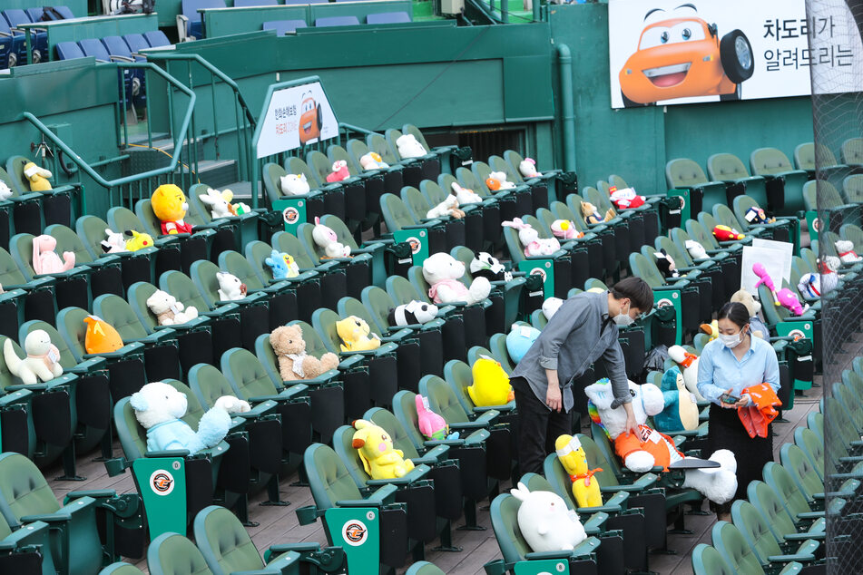 Mitarbeiter des Baseball-Teams Hanwha Eagles platzieren von Fans eingesandte Stofftiere auf der Tribüne des Hanwha Life Insurance Eagles Park.