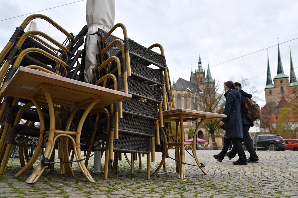 Die Erfurter Innenstadt ist kaum besucht, Stühle und Tische der Restaurants sind zusammengestellt - die Corona-Pandemie hinterlässt auch in Thüringen deutliche Spuren.