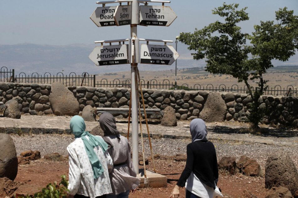Muslimische Frauen gehen an der umstrittenen Grenze zwischen Israel und Syrien auf dem Berg Bental entlang.