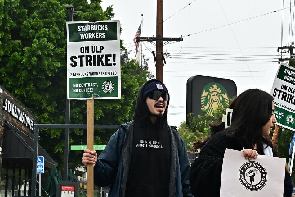 Starbucks workers strike outside a location in Los Angeles, California, to demand collective bargaining agreements on December 24, 2024.