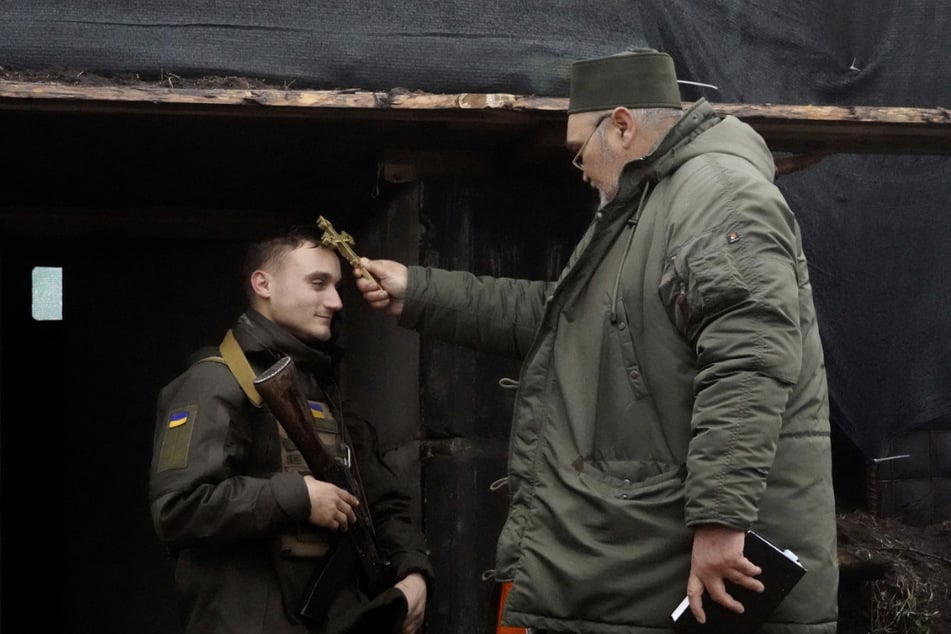 Ein Geistlicher segnet zu Weihnachten einen Soldaten der ukrainischen Nationalgarde nahe der russischen Grenze.