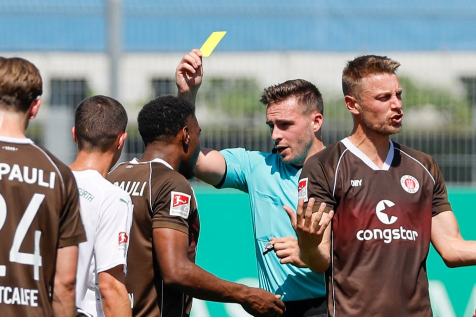 Schiedsrichter Tom Bauer zückte ein ums andere Mal die gelbe Karte für den FC St. Pauli. Hier erhielt Oladapo Afolayan (M) die Verwarnung.