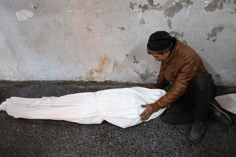 A man mourns over the shrouded body of a relative at Al-Ahli Arab hospital, also known as the Baptist hospital, in Gaza City on January 8, 2025.