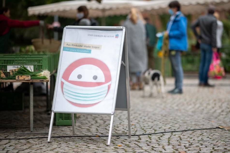 Ein Schild weist auf einem Markt im Esslinger Stadtteil Oberesslingen auf die Verwendung eines Mundschutzes hin. Der Landkreis Esslingen hat als erste Region in Baden-Württemberg die kritische 50er-Corona-Marke überschritten.