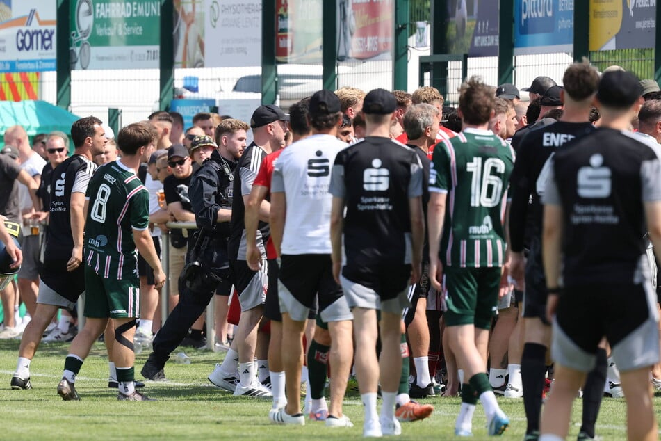 Nach den rassistischen Entgleisungen stürmen Spieler und Verantwortliche Richtung Gästeblock.