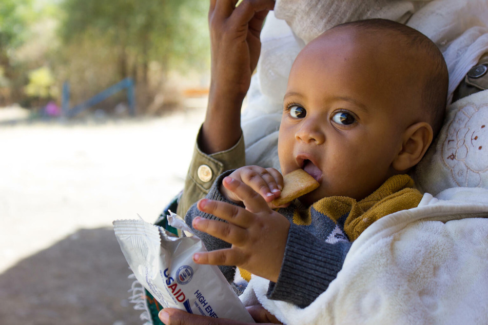 Ein sieben Monate altes Kind erhält im Februar 2021 Nahrungsmittel von UNICEF.