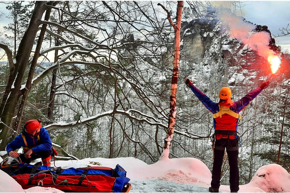 Rettungskräfte der Bergwacht Bad Schandau kümmern sich um den gestürzten Mann und weisen dem Rettungshelikopter den Weg.