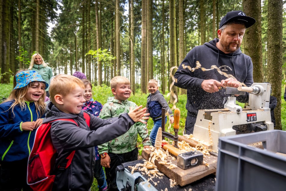 Rund zehn Kilometer von seiner Seiffener Werkstatt entfernt lässt Markus Füchtner (45, r.) die Späne durch den Wald bei Sayda wirbeln.