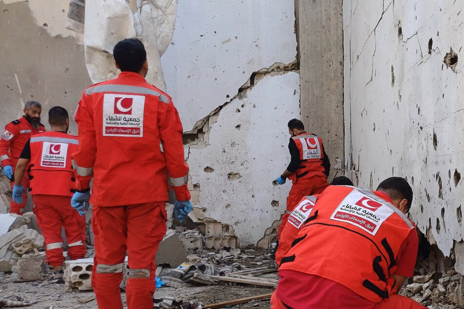Palästinensische Rettungskräfte untersuchen den Ort, an dem ein israelischer Angriff das palästinensische Flüchtlingslager Ain al-Hilwah getroffen hat, und bergen die sterblichen Überreste von Opfern.