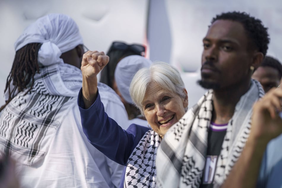 Dr. Jill Stein wears a keffiyeh and raises her fist as she joins Palestine solidarity protesters outside the Democratic National Convention in Chicago, Illinois.