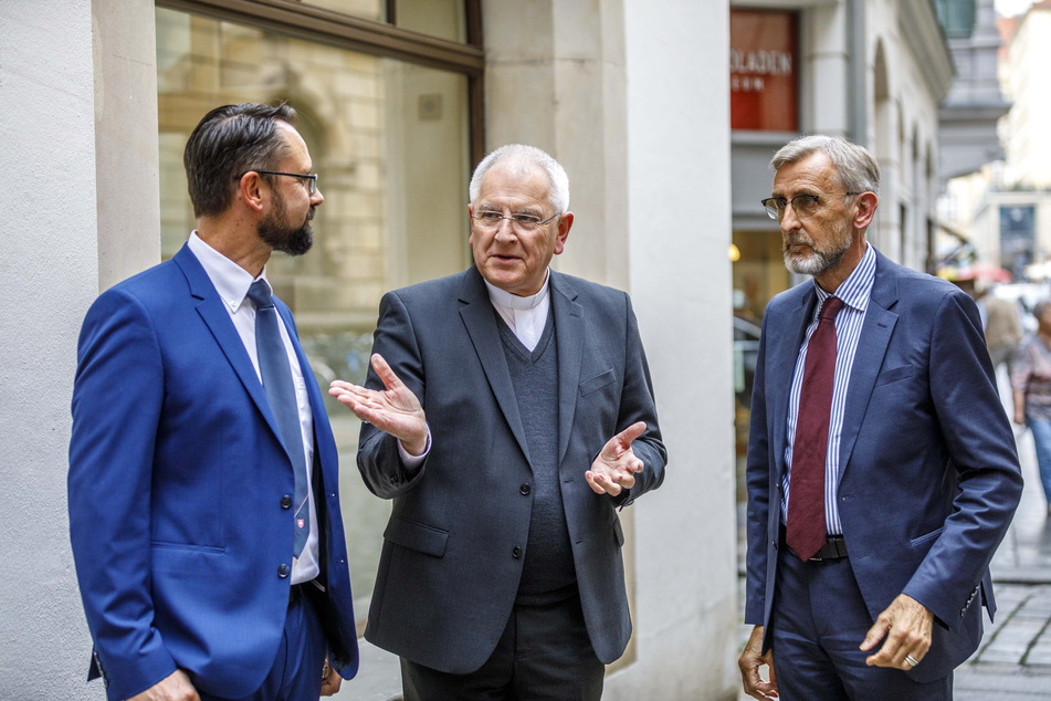 Danny Effenberger (45) von den Maltesern, Bischof Heinrich Timmerevers (70) und Innenminister Armin Schuster (62) in der Schloßstraße vor dem "Treffpunkt Hoffnung".