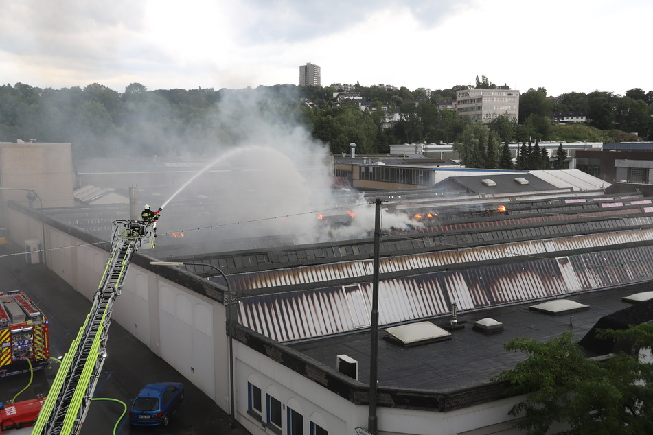 Flammen schlagen auf dem Dach einer Lagerhalle in Wuppertal.