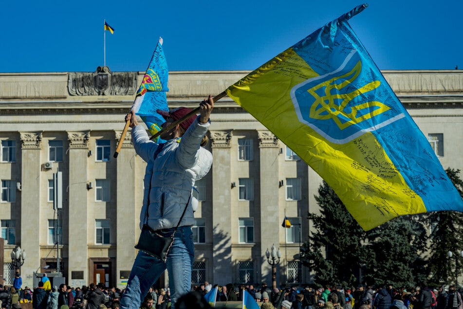Eine Frau schwenkt eine ukrainische Flagge in der Nähe des Regierungsgebäudes von Cherson nach der Befreiung der Stadt durch die ukrainische Armee. (Archivfoto)