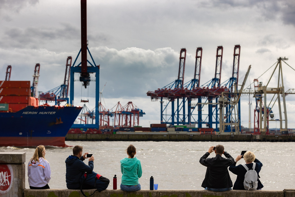 Touristen beobachten bei wolkigem Himmel die Elbe in Hamburg. (Symbolbild)